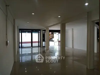 Spacious open-plan interior with glossy floors and large windows for natural light.
