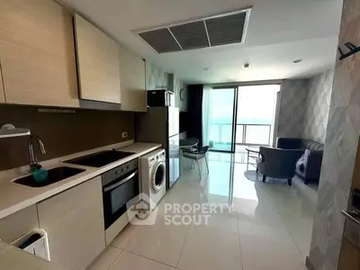 Modern open-layout kitchen and living area with sleek appliances and balcony view.