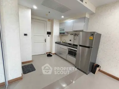Modern kitchen with sleek appliances and elegant wallpaper in a stylish apartment.