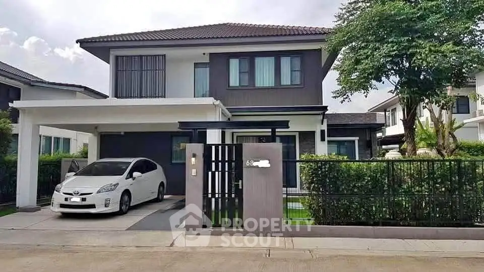 Modern two-story house with carport and landscaped front yard in a suburban neighborhood.