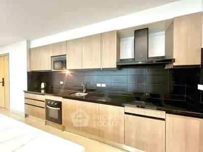 Modern kitchen with sleek black countertops and wooden cabinetry