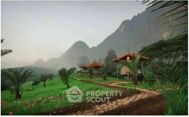 Scenic view of rustic cabins amidst lush greenery and mountains
