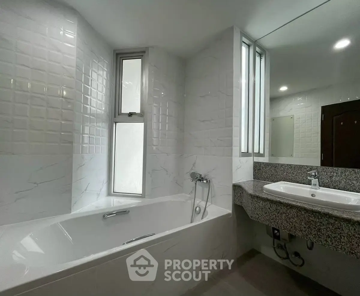 Modern bathroom with sleek bathtub and elegant marble tiles.