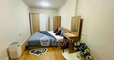 Cozy bedroom with modern decor and wooden furniture, featuring a comfortable bed and stylish accents.