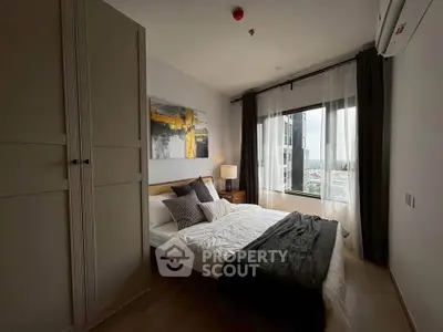 Cozy bedroom with modern decor and large window offering city views