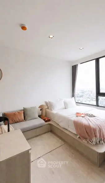 Modern bedroom with large windows and cozy decor in a high-rise apartment.