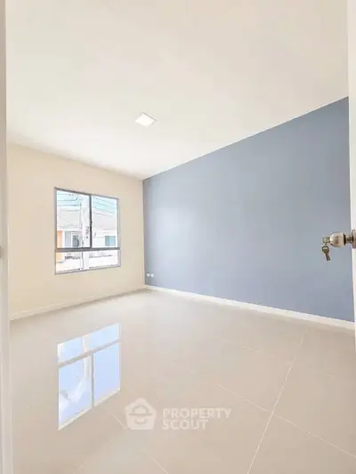 Spacious empty room with large window and glossy tiled floor, perfect for customization.