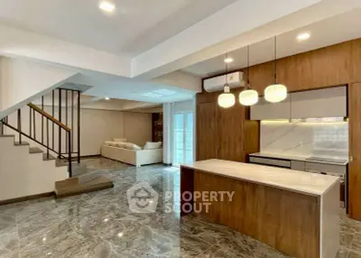 Spacious modern living room with open kitchen and elegant staircase