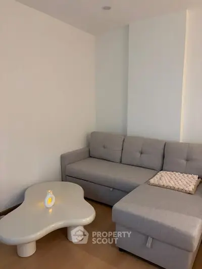 Cozy modern living room with stylish gray sofa and unique coffee table.