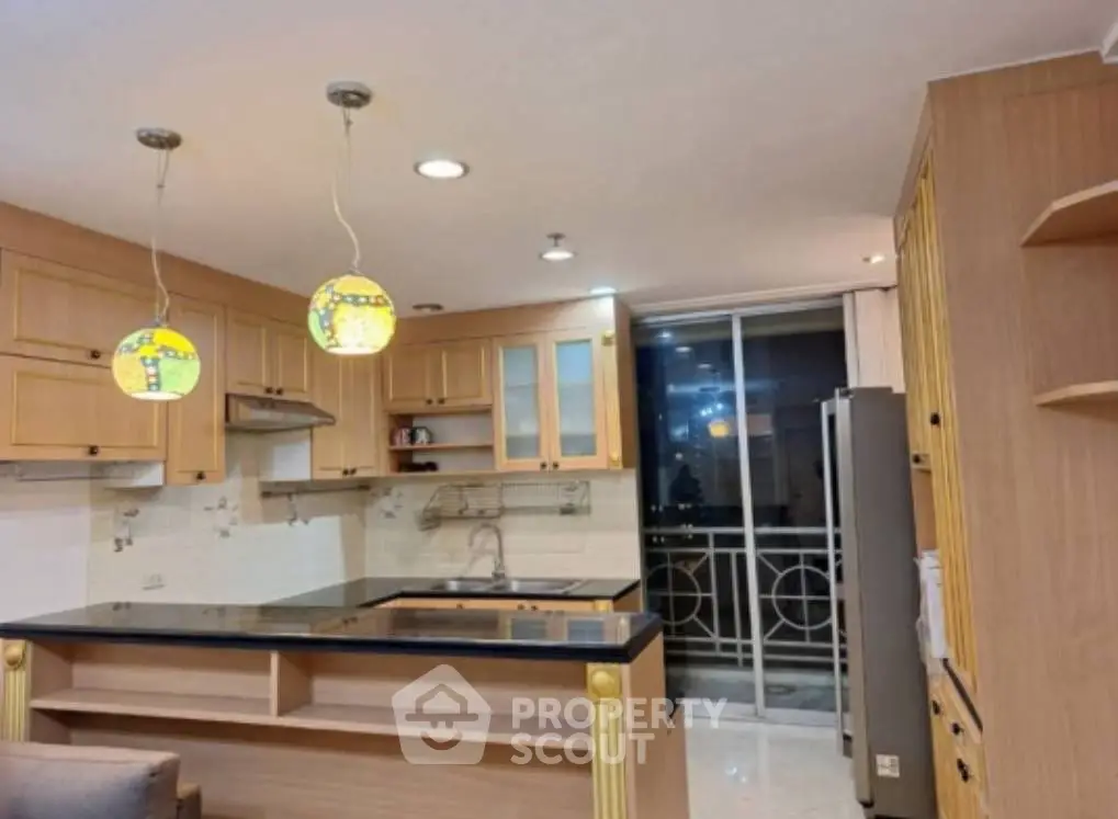 Spacious kitchen with modern design and open layout, featuring stylish lighting and ample storage.