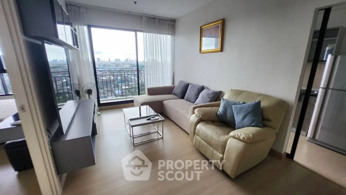 Modern living room with city view, cozy seating, and sleek decor in a high-rise apartment.