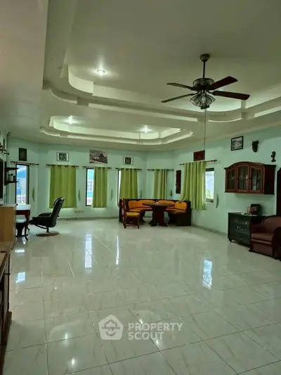 Spacious living room with elegant ceiling design and ample natural light