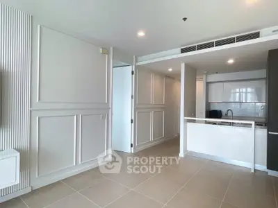 Modern open-plan living area with sleek kitchen and elegant paneling, perfect for contemporary living.