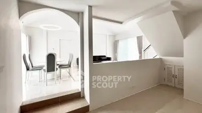 Spacious modern living and dining area with elegant archway and natural light.