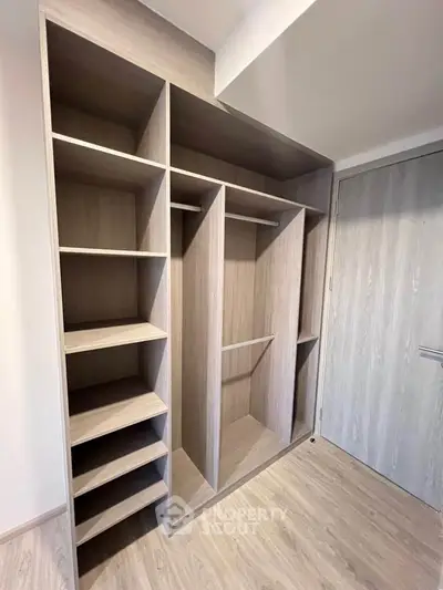 Spacious walk-in closet with modern wooden shelving and ample storage space.