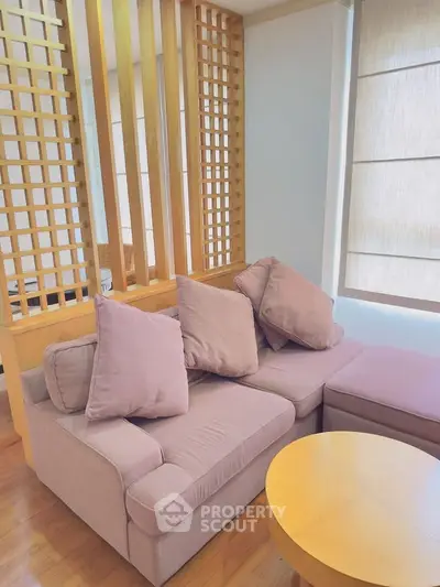Cozy living room with plush sofa and wooden accents, perfect for relaxation.