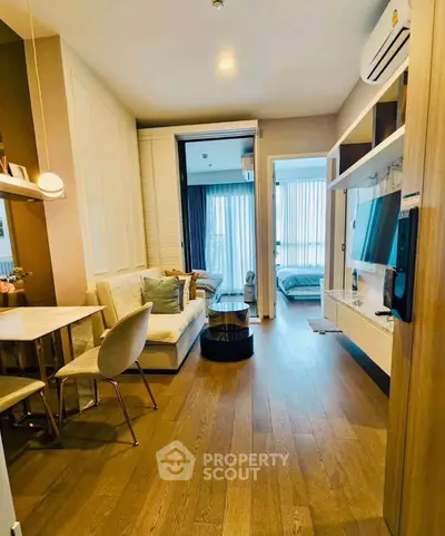 Modern living room with open layout, stylish furniture, and natural light in a cozy apartment.