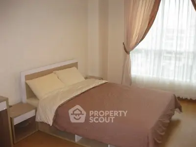 Cozy bedroom with large window and elegant curtains in modern apartment.