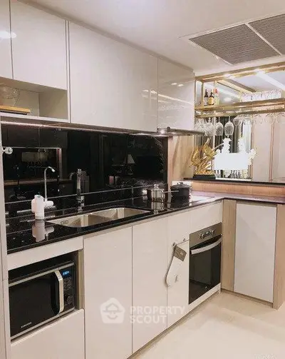 Modern kitchen with sleek cabinetry and built-in appliances, featuring a stylish black countertop.