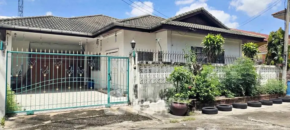 Charming single-story house with gated driveway and lush garden in a serene neighborhood.