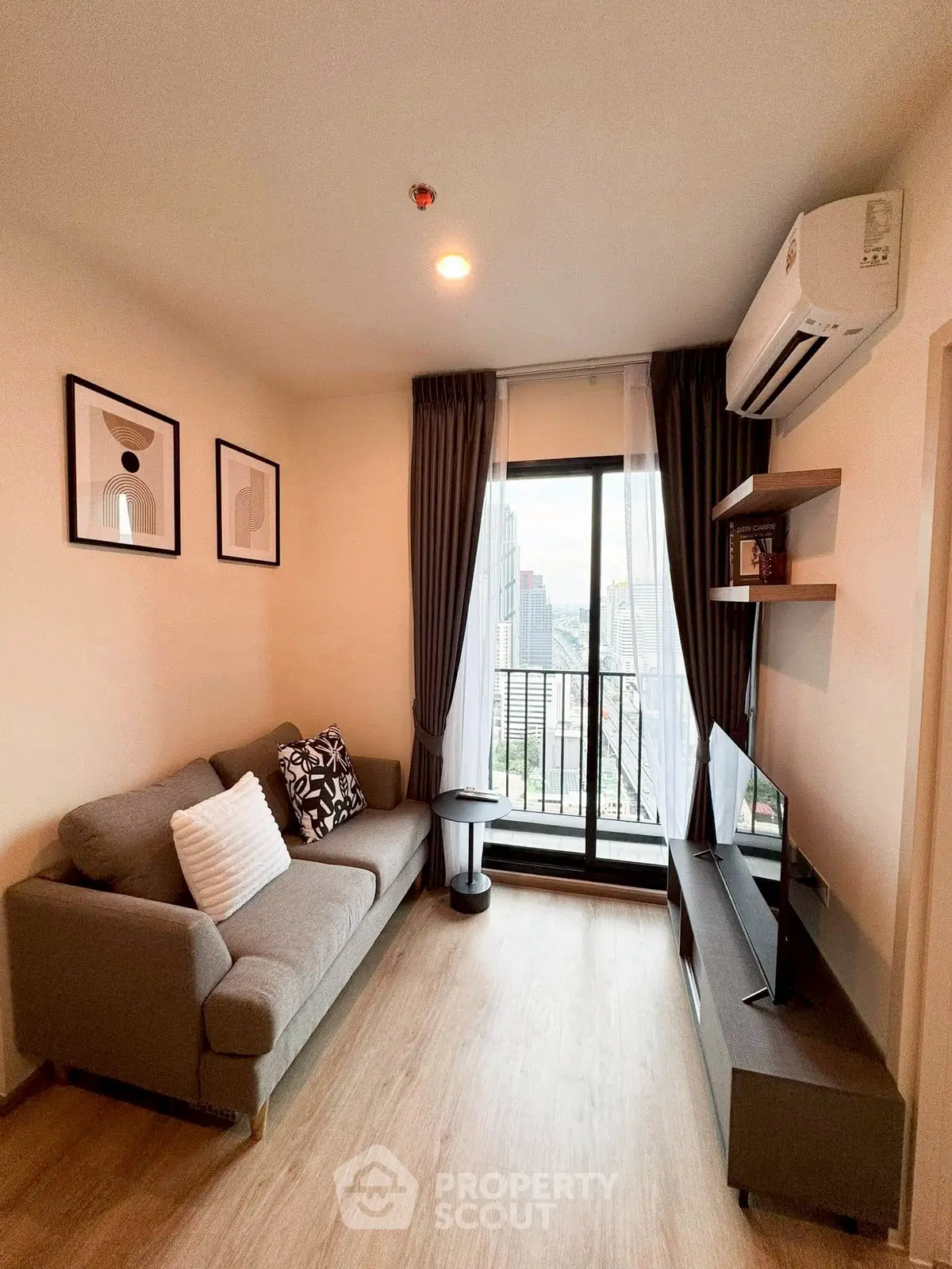 Modern living room with city view, featuring stylish decor and natural light.