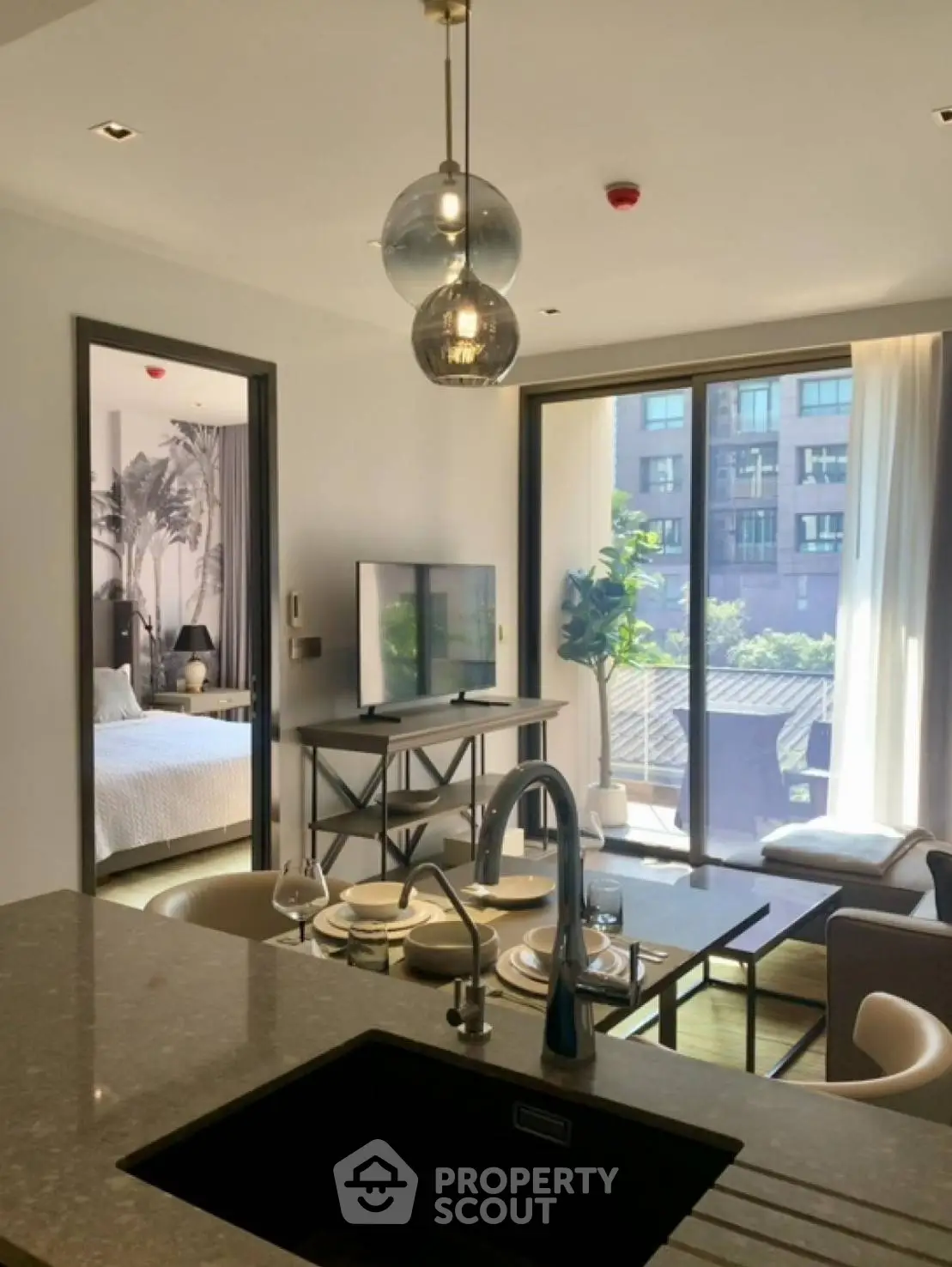 Modern open-plan living room with stylish decor and balcony view in urban apartment.