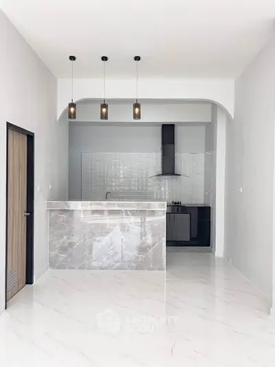 Modern kitchen with marble island and pendant lighting in open layout
