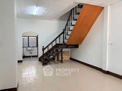Spacious interior with wooden staircase and tiled floor, ideal for modern living.