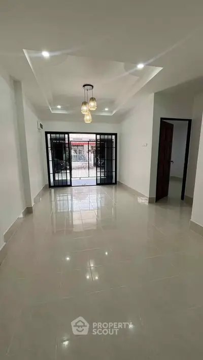 Spacious living room with modern lighting and large windows for natural light.