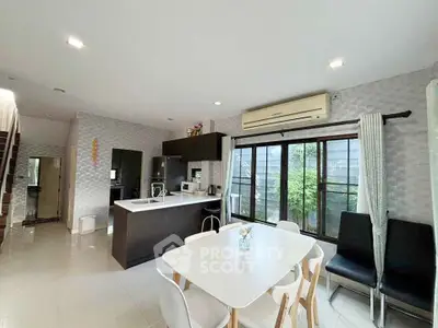 Modern kitchen and dining area with sleek design and natural light