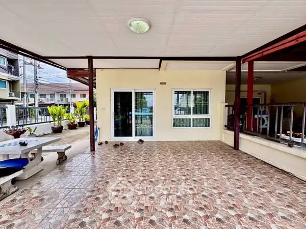 Spacious tiled balcony with seating area and sliding glass doors in a modern home.