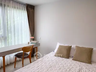Bright bedroom with cozy bed and study desk near large window