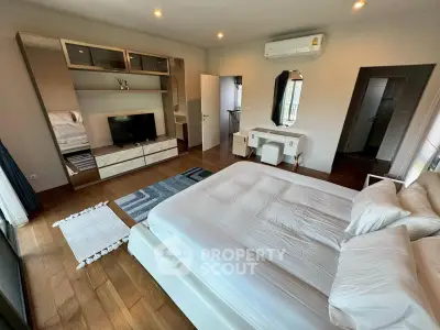 Spacious modern bedroom with elegant decor and wooden flooring