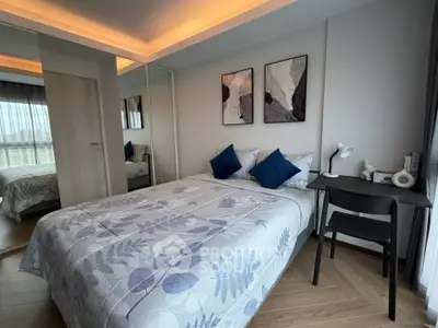 Modern bedroom with stylish decor and natural light, featuring a cozy bed and workspace.