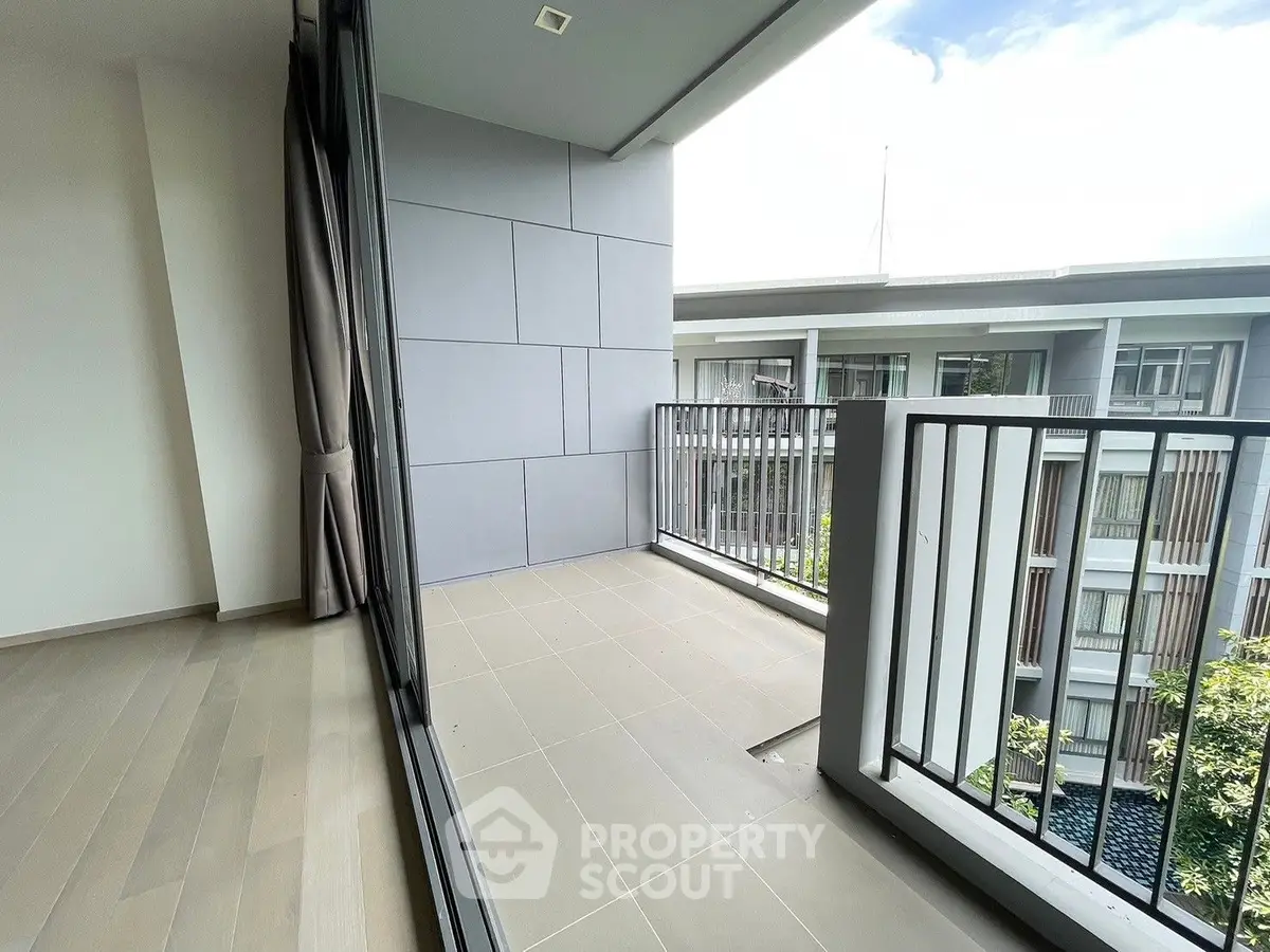 Spacious balcony with modern tiles and a serene view, perfect for outdoor relaxation and entertaining in a contemporary residence.