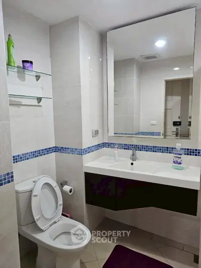 Modern bathroom with sleek fixtures and large mirror in a contemporary apartment.
