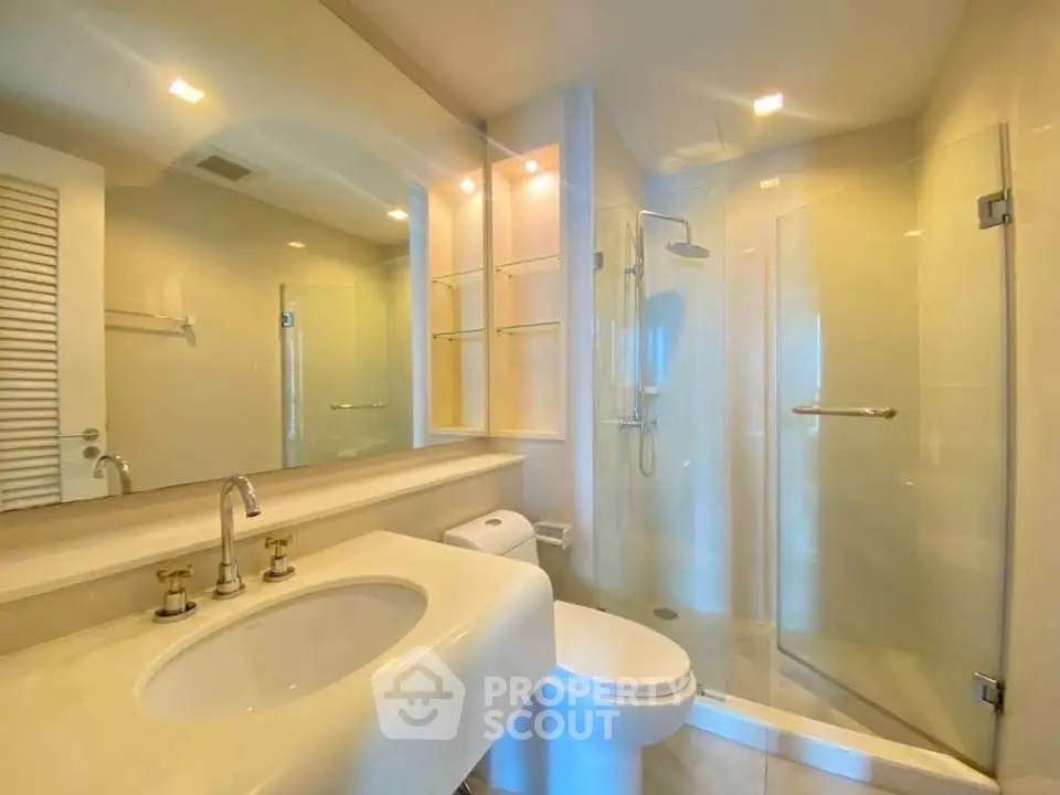 Modern bathroom with glass shower and elegant fixtures in a bright, spacious setting.