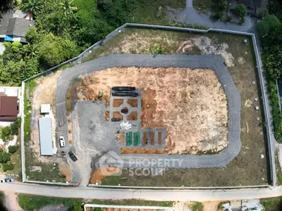Aerial view of a large, undeveloped plot of land with surrounding greenery, ideal for new construction projects.