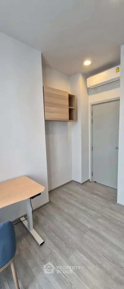 Modern minimalist study room with sleek wooden desk and wall-mounted storage.