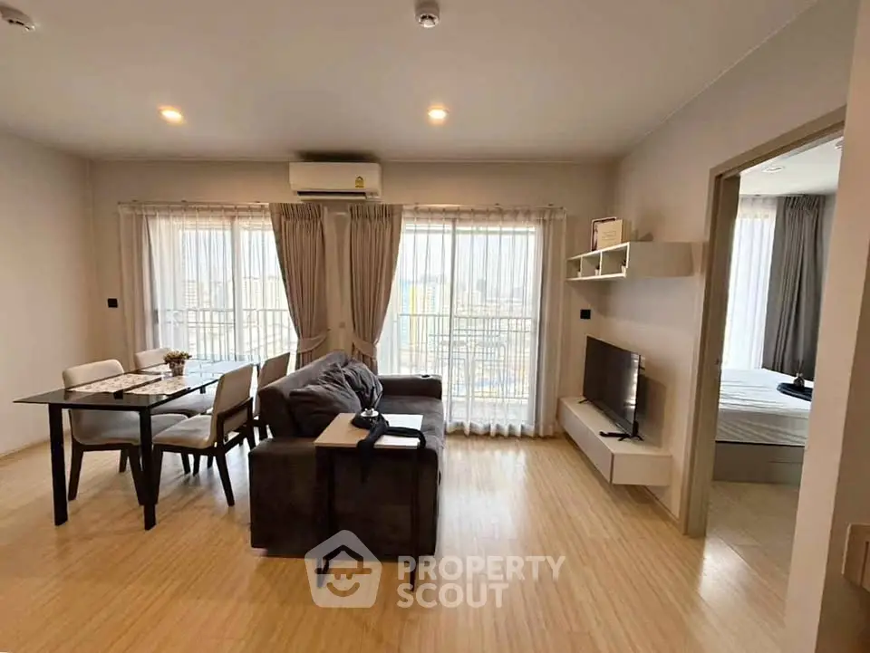Spacious modern living room with dining area and bedroom view, featuring elegant decor and natural light.