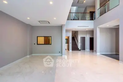 Spacious modern living room with high ceilings and elegant marble flooring.