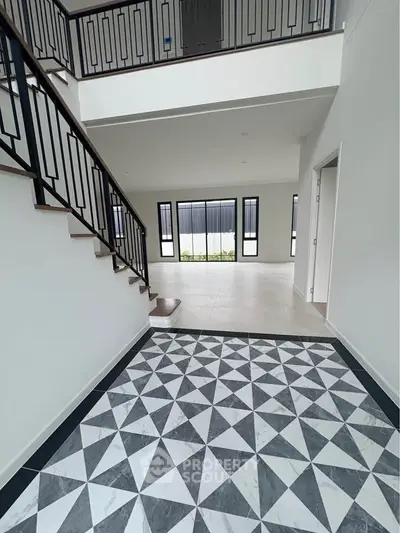 Spacious modern interior with stylish staircase and geometric tile flooring, perfect for contemporary living.