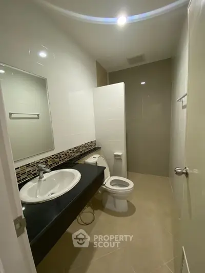 Modern bathroom with sleek fixtures, ample lighting, and a clean, minimalist design, perfect for a contemporary home.