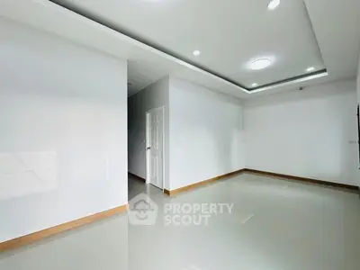 Spacious modern living room with sleek white walls and recessed lighting
