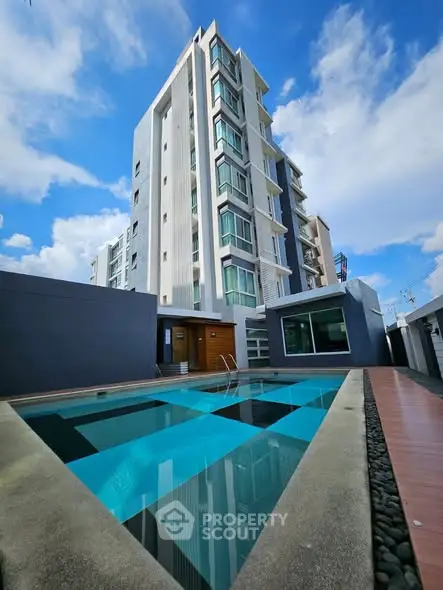Modern apartment building with outdoor pool and clear blue sky