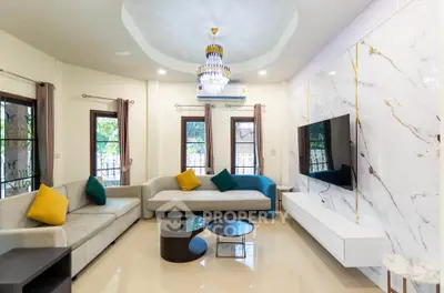 Luxurious living room with elegant chandelier, modern furniture, and marble accent wall with mounted TV.
