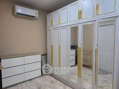 Spacious bedroom with mirrored wardrobe and modern air conditioning unit.