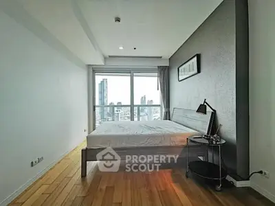 Modern bedroom with city view, featuring sleek design and natural light.