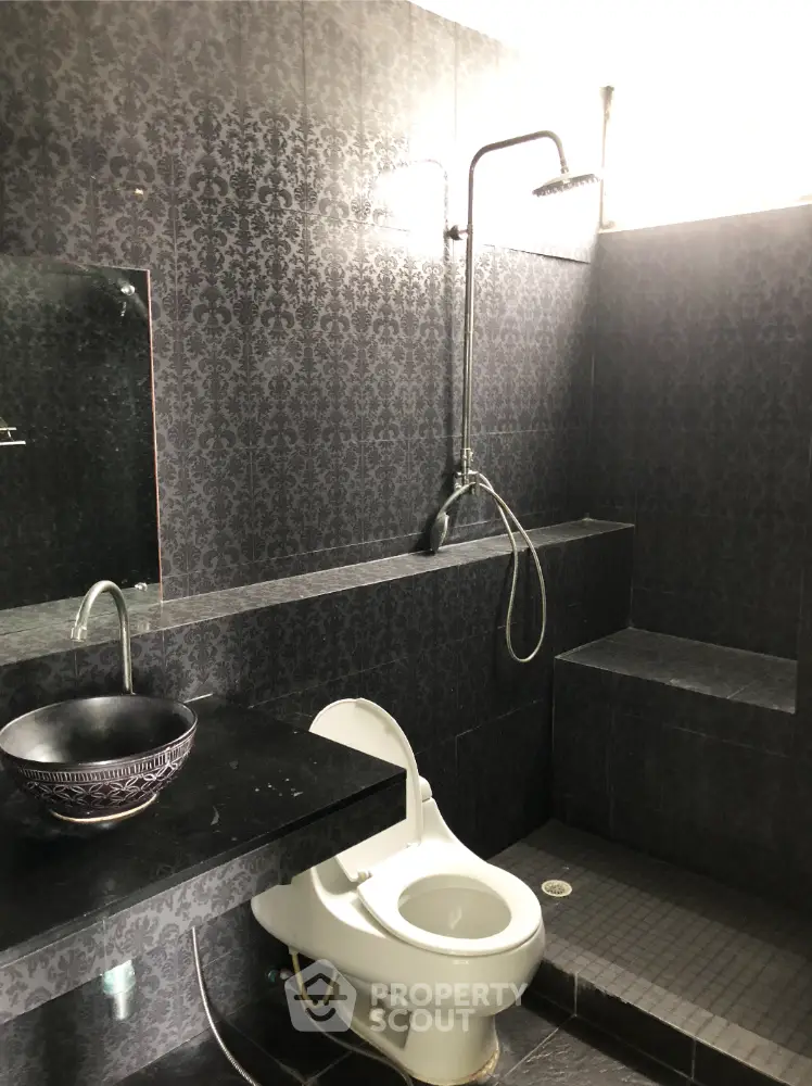 Luxurious black-tiled bathroom with modern fixtures and elegant design