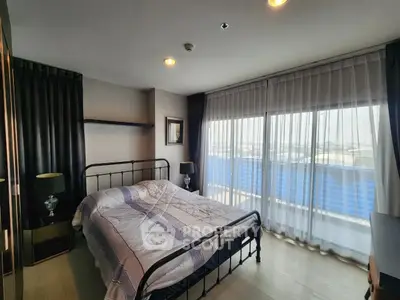 Spacious bedroom with large windows and modern decor in a high-rise apartment.